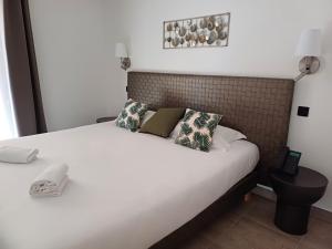 a bedroom with a white bed with pillows at Hôtel Casa Mea in Bastia