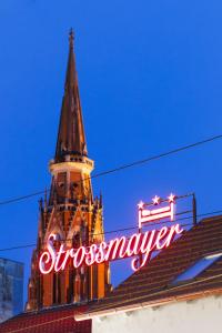 奧西耶克的住宿－Pansion Strossmayer，一座建筑顶部带有标志的钟楼