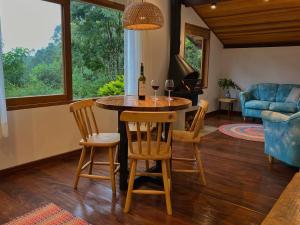uma sala de estar com uma mesa com dois copos de vinho em Pousada Casa Bonita em Visconde de Mauá