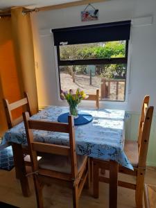 a dining room table and chairs with a table and a window at Gilfach in Clynnog-fawr