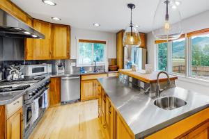 una cocina con armarios de madera y electrodomésticos de acero inoxidable en Hermosa Hideaway, en Durango