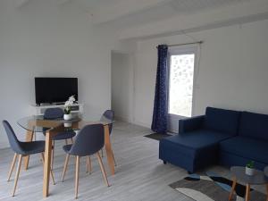 - un salon avec un canapé bleu et une table dans l'établissement Villa du lagon avec piscine, à Saint-Michel-en-lʼHerm