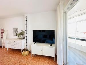 sala de estar con TV de pantalla plana grande en Charming & cosy beach apartment, en Torremolinos