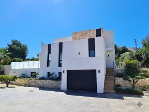 une maison blanche avec un garage dans l'établissement Villa moderna de lujo de nueva construcción a 1km de Playa Fustera - Ref A014 AVANOA PREMIUM RENTALS, à Benissa