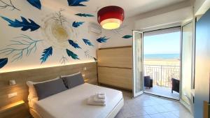 a bedroom with a bed with blue birds on the wall at Art Hotel La Perla in Bellaria-Igea Marina +135 photos