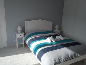- une chambre avec un lit à rayures bleues et blanches dans l'établissement Villa du lagon avec piscine, à Saint-Michel-en-lʼHerm