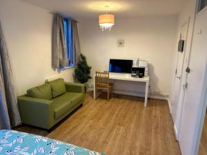 a living room with a couch and a desk with a computer at Overton in London