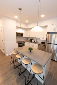 uma cozinha com uma ilha com bancos e um balcão em Modern & Cozy 2 - Bedroom gem mins from NYC em Jersey City