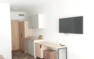 cocina con escritorio y TV en la pared en Apartament 106 Mari - Welle, en Grzybowo