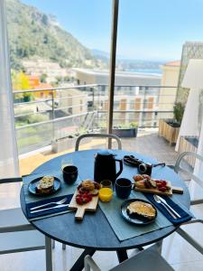 a blue table with breakfast food on a balcony at Penthouse over Monaco in Beausoleil