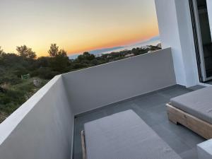 um quarto com uma varanda com vista para o pôr-do-sol em villa of the god em Skala