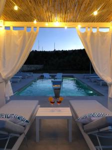 - une piscine avec 2 verres à vin sur une table dans l'établissement CasaKarina - Villa con piscina privata, à Specchia