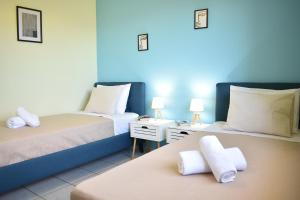 a room with two beds and two tables with lamps at Elounda Holidays Argyro in Elounda