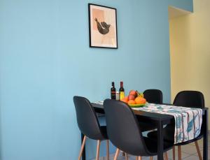 a dining room table with black chairs and a plate of fruit at Elounda Holidays Argyro in Elounda