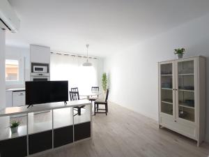 a living room with a tv and a kitchen at Aiguaneu S'Auguer in Blanes