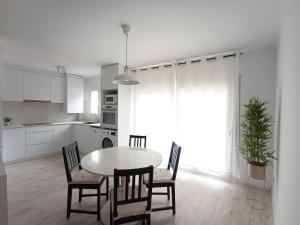 a kitchen and dining room with a table and chairs at Aiguaneu S'Auguer in Blanes