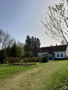 uma casa branca com um grande quintal com um campo de relva em Placówka - tu życie płynie wolniej em Wydminy