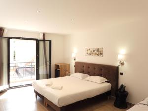 a bedroom with a large bed and a large window at Hôtel Casa Mea in Bastia +37 photos