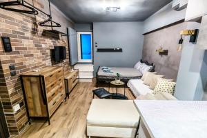 a living room with a couch and a brick wall at Happiness studio with terrace. in Thessaloniki