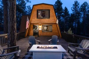 une maison en bois avec une cheminée sur une terrasse dans l'établissement Grand Canyon Cabin! One hour and 10 minutes to the South Entrance!, à Williams