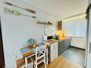 a small kitchen with a table and a counter top at Złote Piaski Pensjonat z basenem in Darłowo