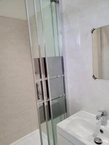 a glass shower in a bathroom with a sink at Nice single bedroom near QMC in Nottingham