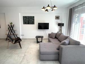 a living room with a couch and a tv at Bridge House Corfu in Potamós