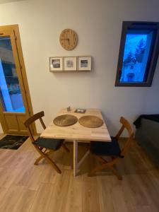 een tafel met twee stoelen en een klok aan de muur bij Charmant appartement in Argelès-Gazost +23 foto's