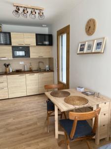 een keuken met een tafel en stoelen in een kamer bij Charmant appartement in Argelès-Gazost