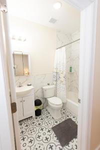 Baño blanco con aseo y lavamanos en Elegant Modern 3-Bed Apt near NYC en Jersey City