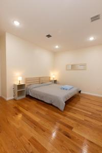 a bedroom with a bed and a wooden floor at Elegant Modern 3-Bed Apt near NYC in Jersey City