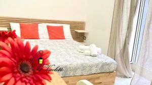 een slaapkamer met een bed met een rode bloem bij Il Vicoletto in Napels