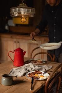 a person holding a plate of pizza on a table at The cabin at Abberley Glamping in Abberley