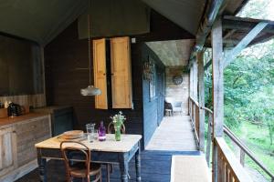 a table and chairs on the porch of a house at The cabin at Abberley Glamping in Abberley