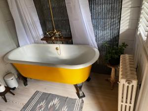 阿伯利的住宿－The cabin at Abberley Glamping，客房内的浴室设有黄色浴缸