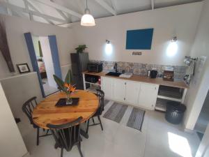 a kitchen with a wooden table and chairs at Paradise in the City - Cottage One in Port Elizabeth