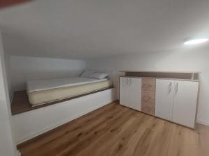 a small room with a bed and a cabinet at SPRING APT with garden and FREE secure parking in Domžale