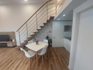 a dining room with a table and chairs and a staircase at SPRING APT with garden and FREE secure parking in Domžale