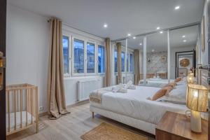 ein Schlafzimmer mit zwei Betten und einem großen Spiegel in der Unterkunft La Villa - Piscine / Karaoké / Jeux in Fontaine + 69 Fotos