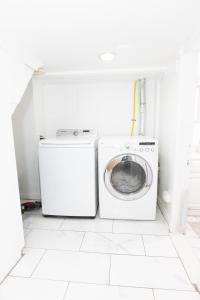 a white laundry room with a washer and dryer at Chic 3BR Hideaway mins from NYC in Jersey City