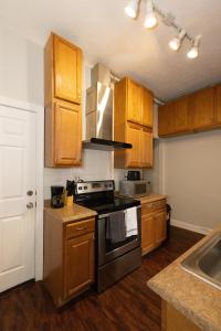 a kitchen with wooden cabinets and a stove top oven at Chic 3BR Hideaway mins from NYC in Jersey City