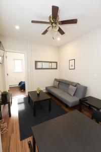 a living room with a couch and a ceiling fan at Chic 3BR Hideaway mins from NYC in Jersey City