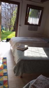 1 dormitorio con 2 camas y ventana en agriturismo il riccio, en Cedegolo