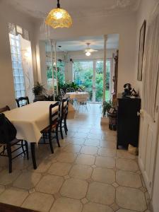 een eetkamer met een tafel en stoelen en een kamer met een eetkamer bij Rez de chaussée et 1er étage et jardin dans Maison individuelle in Enghien-les-Bains