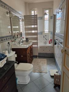 a bathroom with a toilet and a sink and a tub at Rez de chaussée et 1er étage et jardin dans Maison individuelle in Enghien-les-Bains
