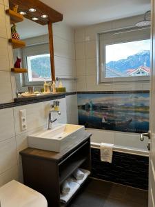 a bathroom with a sink and a tub and a window at Ferienwohnung-Königsschlösser in Füssen
