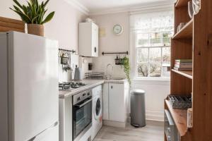 a white kitchen with a stove and a dishwasher at Beautiful apartment in Bath in Bath
