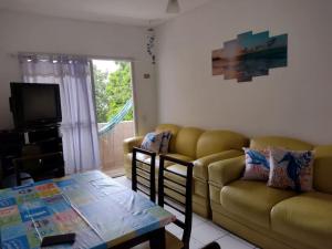 a living room with a couch and a table at apto na praia da enseada in Guarujá