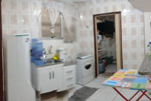 a white kitchen with a sink and a mirror at apto na praia da enseada in Guarujá