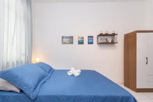ein Schlafzimmer mit einem blauen Bett und einem weißen Handtuch darauf in der Unterkunft Novo e Confortável Studio no RJ/Lapa Circo Voador in Rio de Janeiro